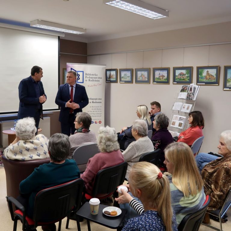 Dwaj mężczyźni w garniturach stoją przed publicznością